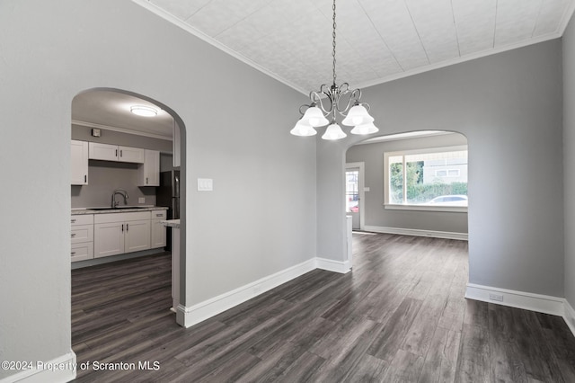 unfurnished dining area with a chandelier, dark hardwood / wood-style flooring, crown molding, and sink