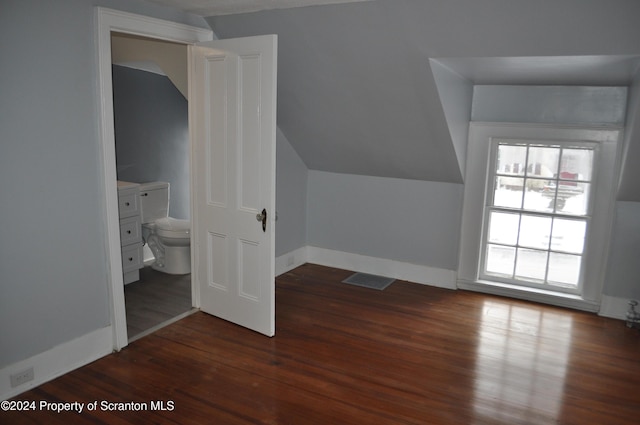 additional living space with dark wood-type flooring and vaulted ceiling