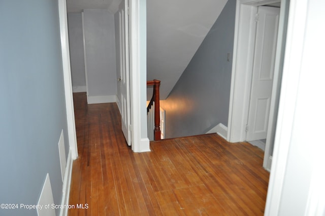 hallway with vaulted ceiling and hardwood / wood-style flooring