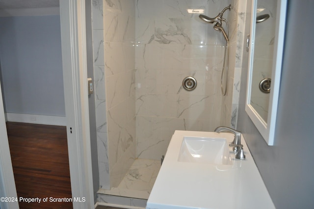 bathroom with tiled shower and vanity