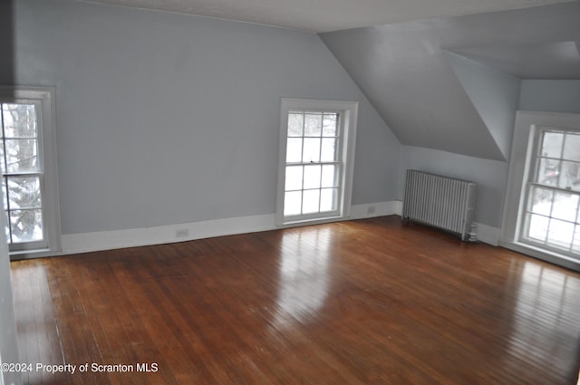 bonus room with vaulted ceiling, radiator, and dark wood-type flooring