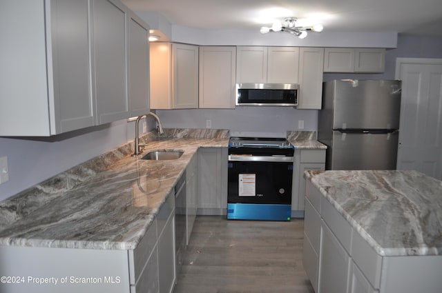 kitchen with gray cabinets, light stone counters, sink, and appliances with stainless steel finishes