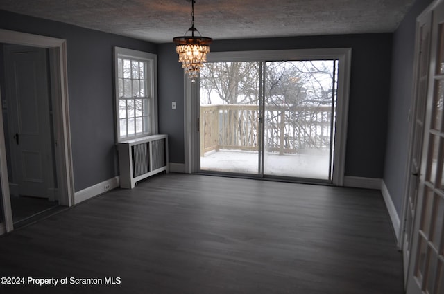 unfurnished dining area with a chandelier, dark wood-type flooring, and a healthy amount of sunlight