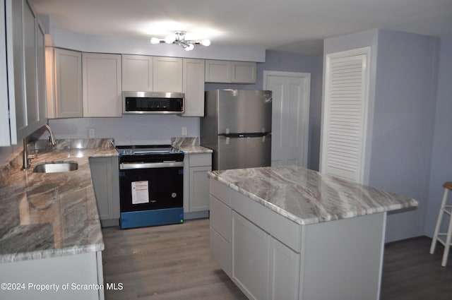 kitchen featuring gray cabinetry, a center island, sink, and appliances with stainless steel finishes