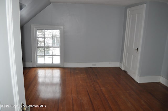 spare room featuring lofted ceiling and dark hardwood / wood-style floors