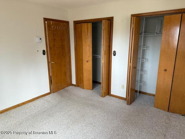 166 Tanglewod Dr, Greentown, PA 18426 - unfurnished bedroom with carpet, two closets, and baseboards