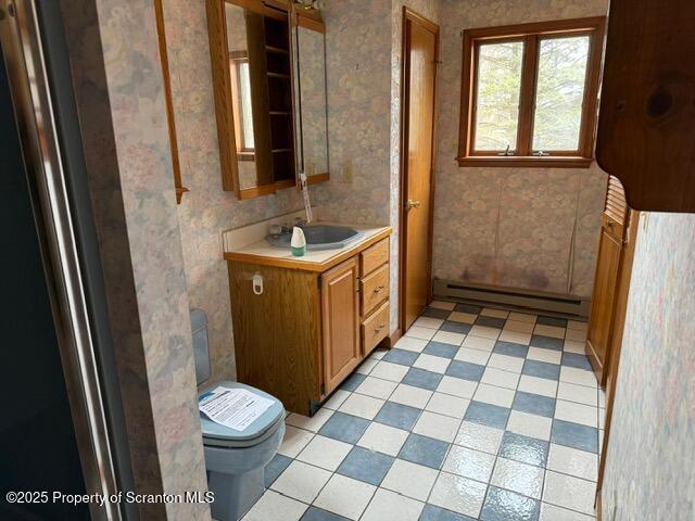 166 Tanglewod Dr, Greentown, PA 18426 - half bath featuring toilet, vanity, tile patterned flooring, baseboard heating, and wallpapered walls