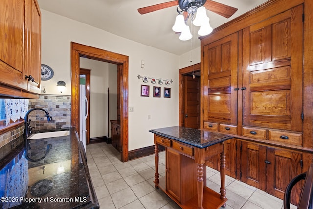 1012 Sunset St, Scranton, PA 18509 - kitchen featuring ceiling fan, light tile patterned floors, brown cabinets, and dark stone countertops