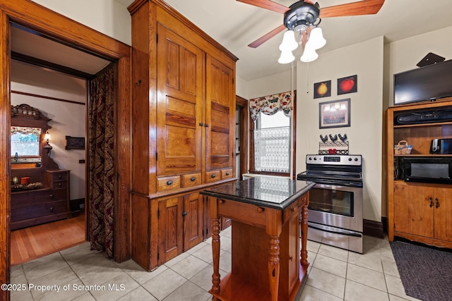 1012 Sunset St, Scranton, PA 18509 - kitchen featuring stainless steel range with electric stovetop, black microwave, ceiling fan, brown cabinets, and a center island
