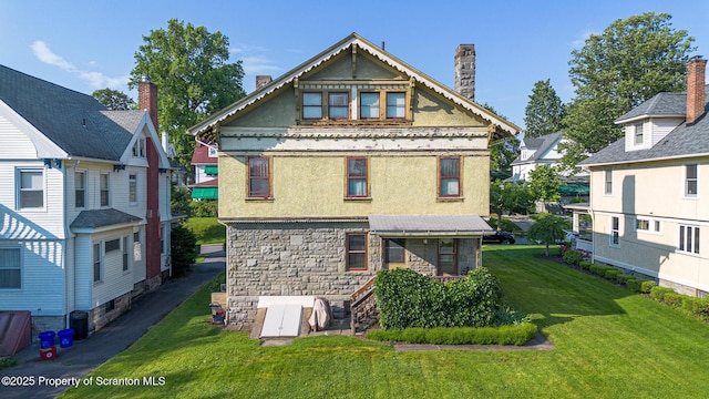 1012 Sunset St, Scranton, PA 18509 - rear view of house featuring stucco siding, a lawn, a chimney, and stone siding