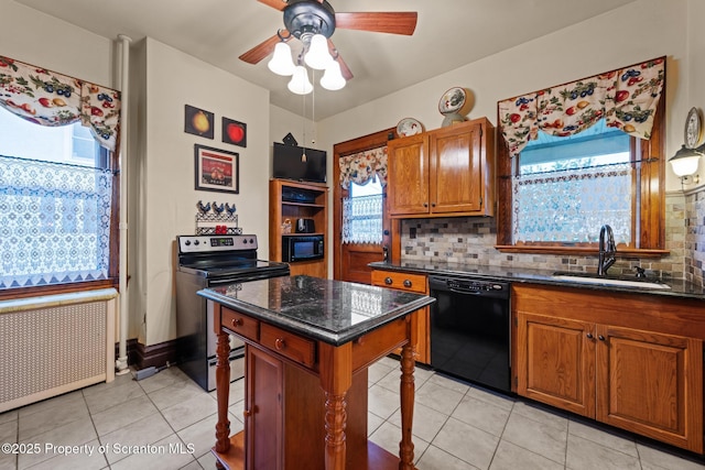 1012 Sunset St, Scranton, PA 18509 - kitchen with black appliances, brown cabinetry, radiator heating unit, light tile patterned floors, and decorative backsplash