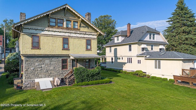 1012 Sunset St, Scranton, PA 18509 - back of house with a chimney, stucco siding, and a lawn