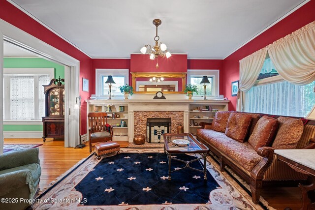 1012 Sunset St, Scranton, PA 18509 - living area with wood finished floors, crown molding, a chandelier, and a high end fireplace