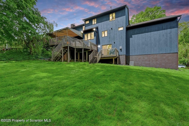 993 Oakmont Rd, Clarks Summit, PA 18411 - back of property with stairs, a wooden deck, and a lawn