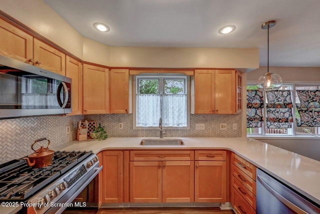 993 Oakmont Rd, Clarks Summit, PA 18411 - kitchen with stainless steel appliances, a sink, light countertops, backsplash, and decorative light fixtures