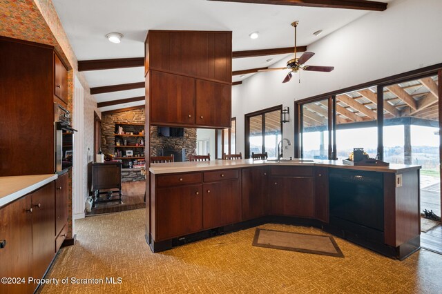 kitchen featuring kitchen peninsula, ceiling fan, lofted ceiling with beams, dishwasher, and sink