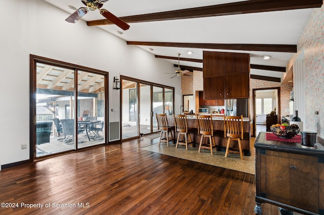 dining space with beam ceiling, ceiling fan, and dark hardwood / wood-style floors