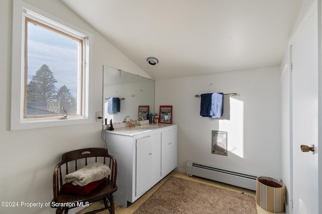 bathroom featuring vanity, a baseboard heating unit, and vaulted ceiling