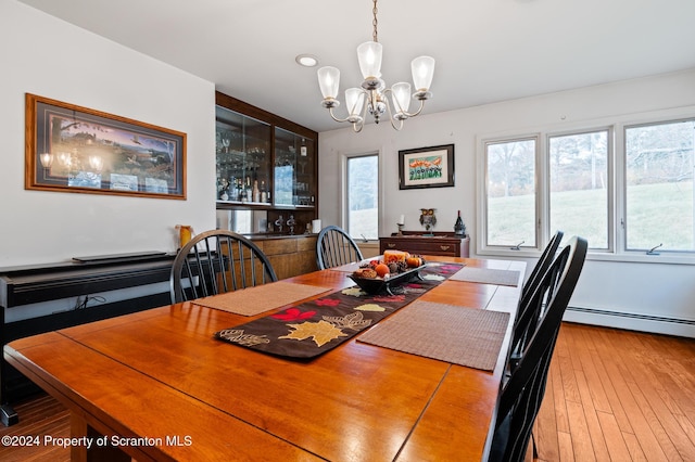 dining room with hardwood / wood-style floors, a chandelier, and a baseboard radiator