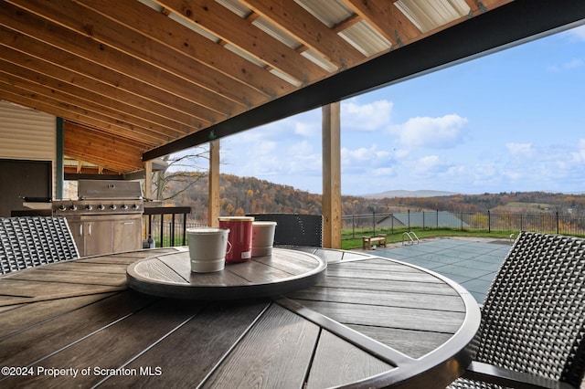 deck with a grill and a mountain view