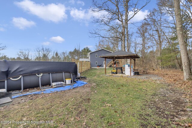 view of yard featuring a gazebo and a covered pool