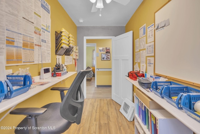 home office with light hardwood / wood-style flooring and ceiling fan