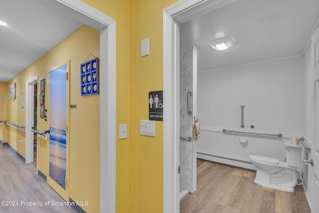 bathroom with toilet, wood-type flooring, and baseboard heating