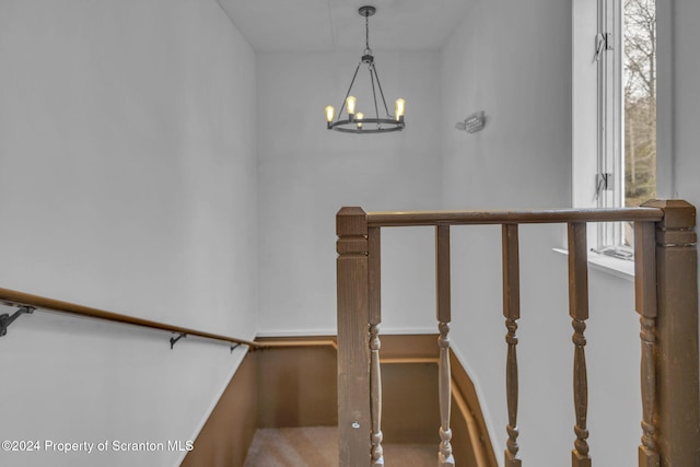 stairway featuring a chandelier