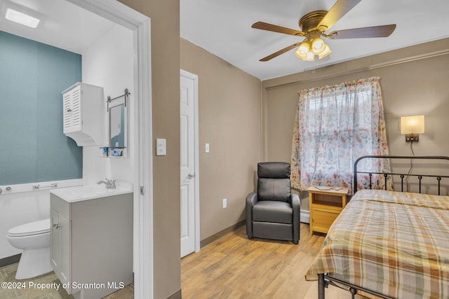 bedroom featuring ensuite bath, ceiling fan, light hardwood / wood-style floors, and a baseboard radiator