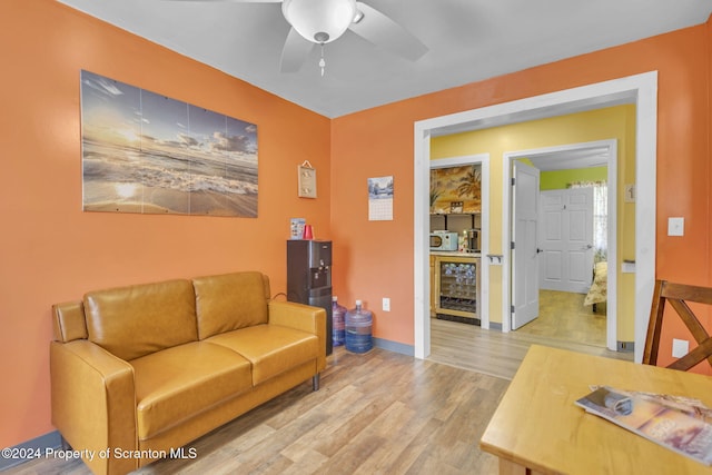 living room featuring light wood-type flooring, wine cooler, and ceiling fan