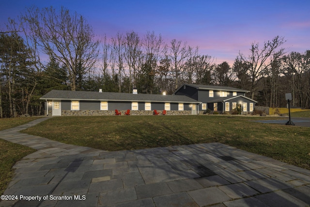 view of front facade with a lawn and a patio area