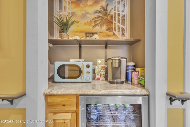 bar with light brown cabinets and beverage cooler