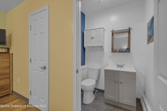 bathroom with vanity, toilet, and a baseboard heating unit