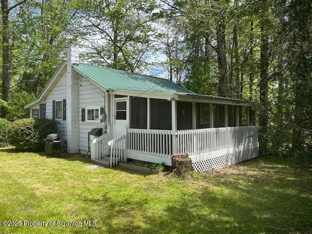 285 Branch Rd, Greentown, PA 18426 - rear view of house with a sunroom, a chimney, a yard, and metal roof