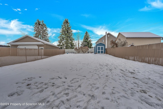 yard covered in snow with a storage unit