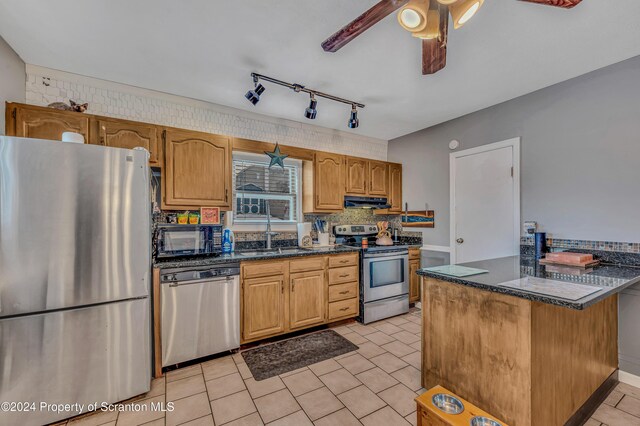 kitchen featuring ceiling fan, sink, kitchen peninsula, exhaust hood, and appliances with stainless steel finishes