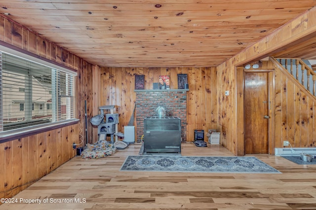 living room with wood walls, wooden ceiling, and light wood-type flooring