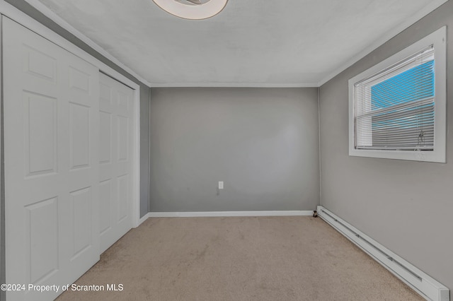 unfurnished bedroom with light carpet, a closet, ornamental molding, and a baseboard heating unit