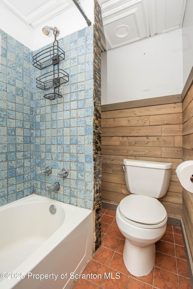 bathroom with a washtub, tile patterned flooring, and toilet