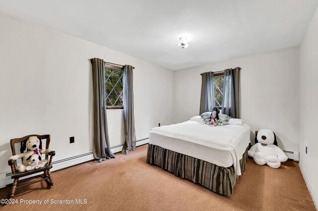 bedroom featuring light colored carpet and a baseboard heating unit