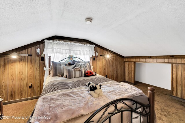 carpeted bedroom with lofted ceiling, wood walls, and a textured ceiling