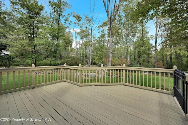 wooden terrace featuring a lawn