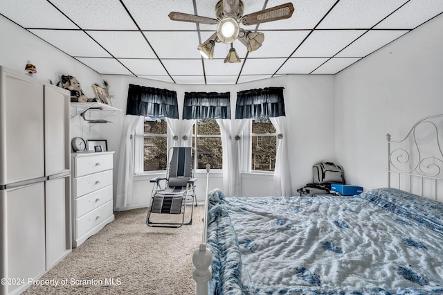 bedroom featuring carpet, ceiling fan, and a drop ceiling