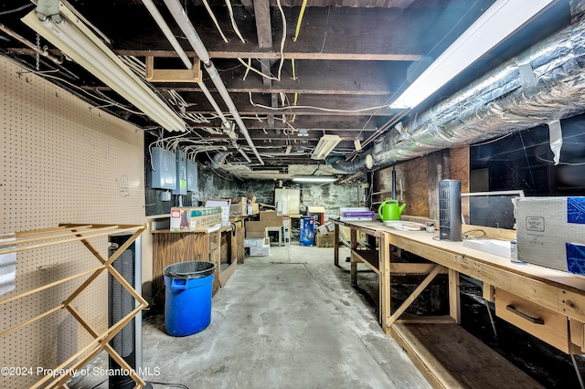 basement with a workshop area and electric panel