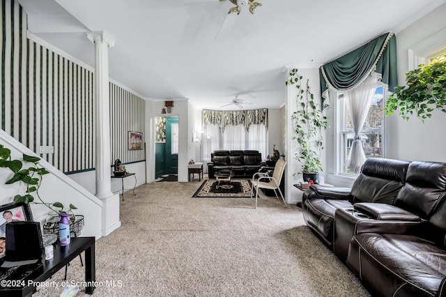 carpeted living room featuring ceiling fan, crown molding, and decorative columns