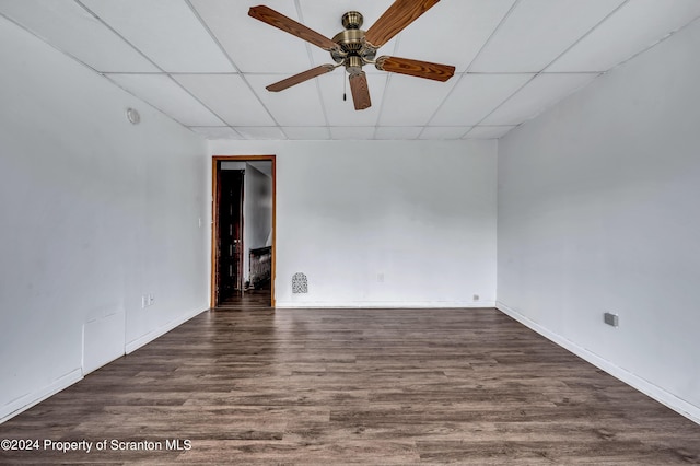 spare room featuring a drop ceiling, ceiling fan, and dark hardwood / wood-style flooring