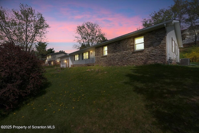 906 Violet Ter, Clarks Summit, PA 18411 - property exterior at dusk with central AC, a yard, and stone siding