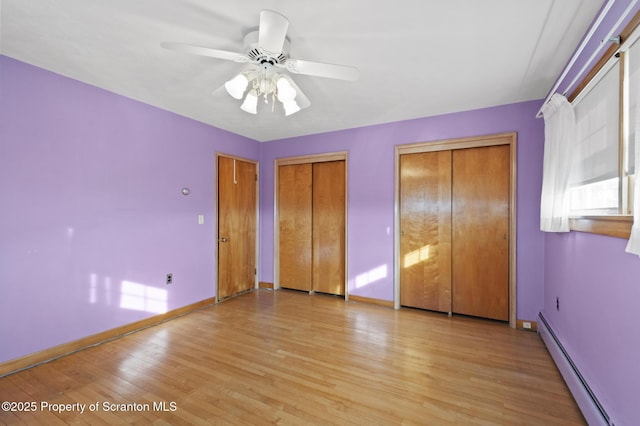 817 Miles Ave, Dickson City, PA 18447 - unfurnished bedroom with a baseboard radiator, light wood-style floors, multiple closets, ceiling fan, and baseboards