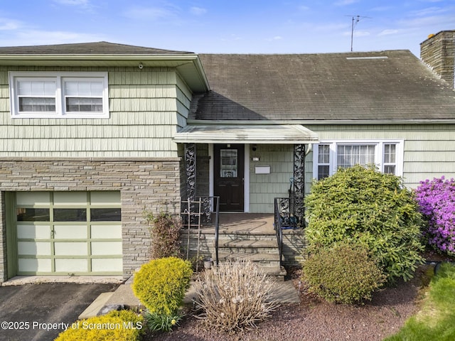 817 Miles Ave, Dickson City, PA 18447 - view of front of house with driveway, stone siding, a chimney, roof with shingles, and an attached garage