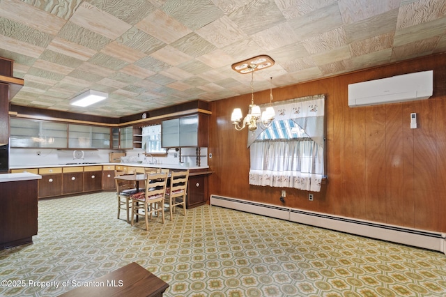 817 Miles Ave, Dickson City, PA 18447 - kitchen with a baseboard heating unit, open shelves, light countertops, a wall mounted AC, and a notable chandelier